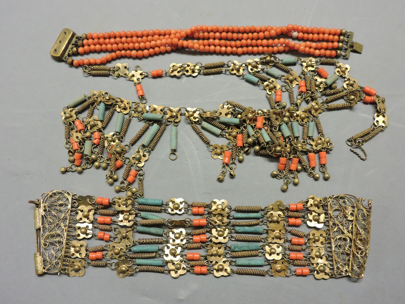 A four row coral bead bracelet, with gilt box clasp, three beads deficient, an Egyptian style blue