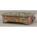 An early 20th century bronze jardinière, the rounded rectangular body engraved with gilt shells
