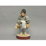 A Russian Gardner Factory biscuit porcelain figure of a street vendor, impressed and red printed