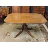 A George IV mahogany supper table, with a turned column on brass capped legs with castors