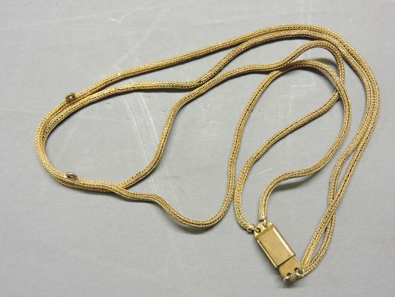 A two row fox tail chain, pendant deficient, with later gilt metal clasp, chain tested as