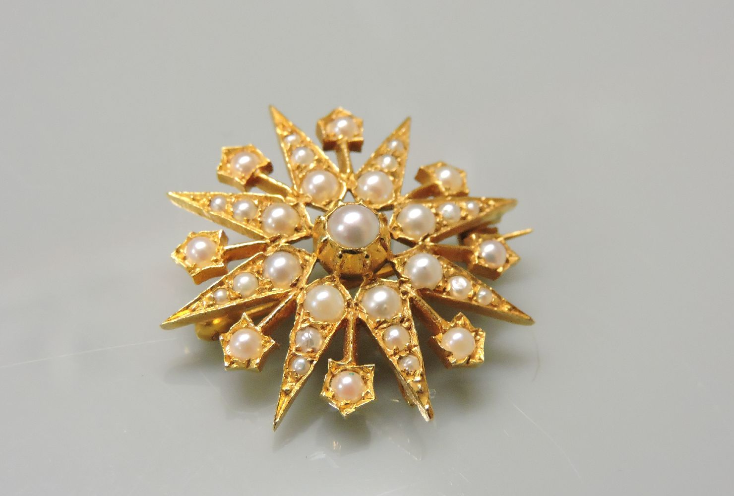 A 9ct gold reproduction cultured pearl star burst brooch