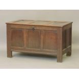 An early 18th century oak three panelled coffer, with recessed panelled top, arcaded frieze, chip