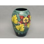 A Moorcroft vase, with flowers, on a two tone blue ground, 18cm