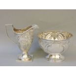 A Victorian silver cream jug, Nathan & Hayes, Birmingham 1889, the part reeded body with scroll