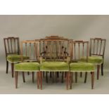 A set of eight Sheraton style mahogany dining chairs, with square backs, over stuffed seats and