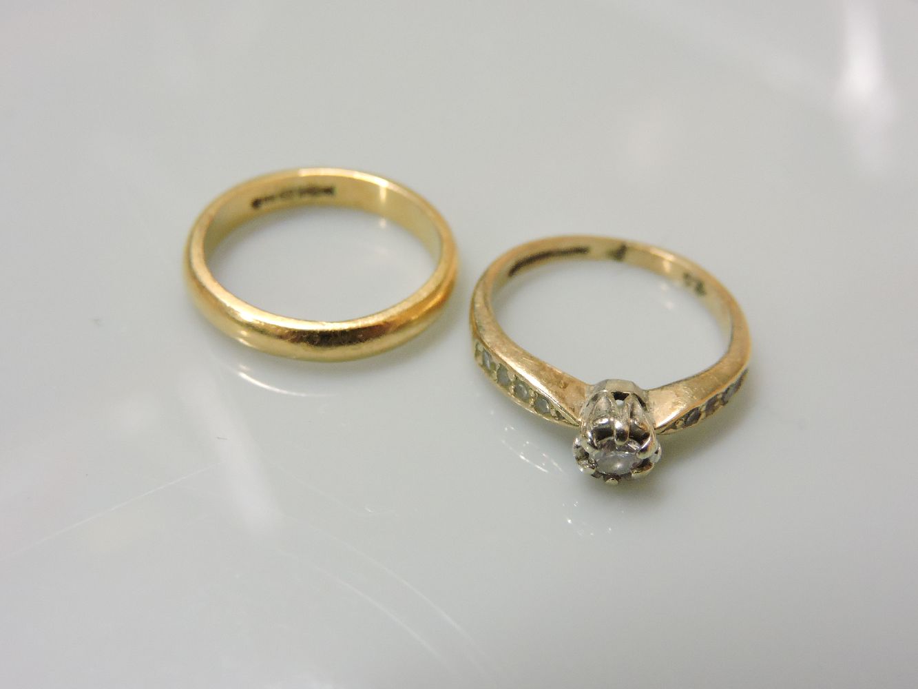 A 9ct gold single stone diamond ring, with diamond set shoulders, and an 18ct gold D shaped plain