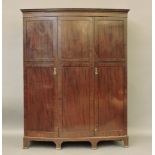 An Edwardian bow front triple door wardrobe, 155cm wide, 195cm high