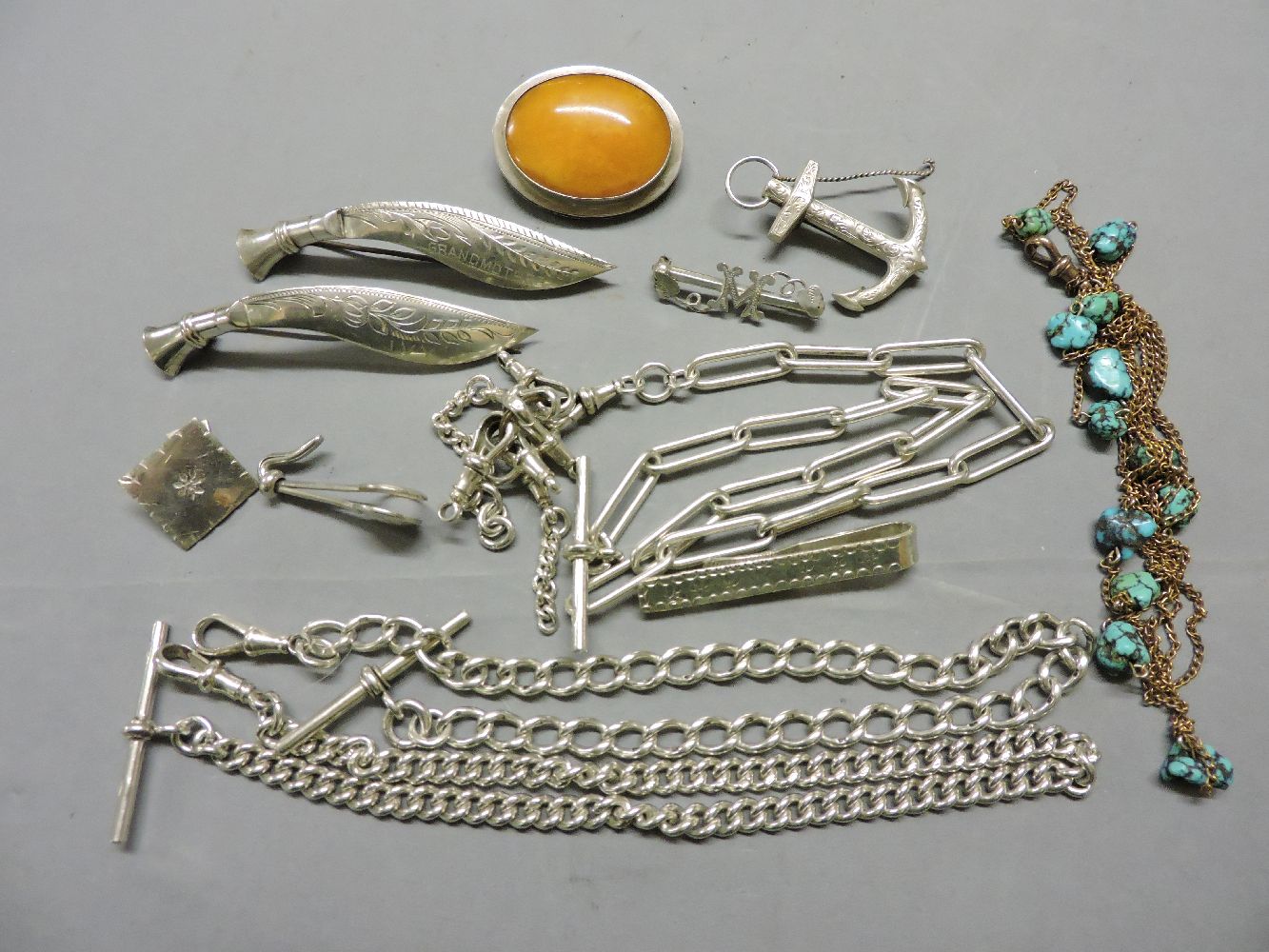 A rolled gold guard chain, set with free form turquoise matrix, an amber brooch in a white metal