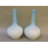 A pair of Victorian blue overlaid vases, of bottle form, with white floral sprays, 23.5cm high, from