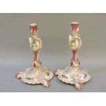 A pair of late 19th century Berlin candlesticks, hand painted with 18th century figures