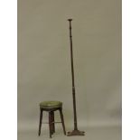 An early 19th century mahogany piano stool, having a green leather and studwork revolving seat,