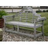 A pair of teak Lutyens style garden seats, with shaped back and slatted seat, each approximately