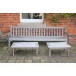 A large teak garden bench, with slatted back seats and open arms, together with two matching