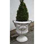 A composite white painted garden vase of urn form, decorated with floral swags and planted with a