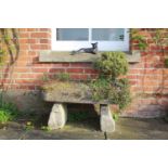 A carved stone 'D' shaped trough, with two cast stone supports, planted with an ancient bonsai tree,