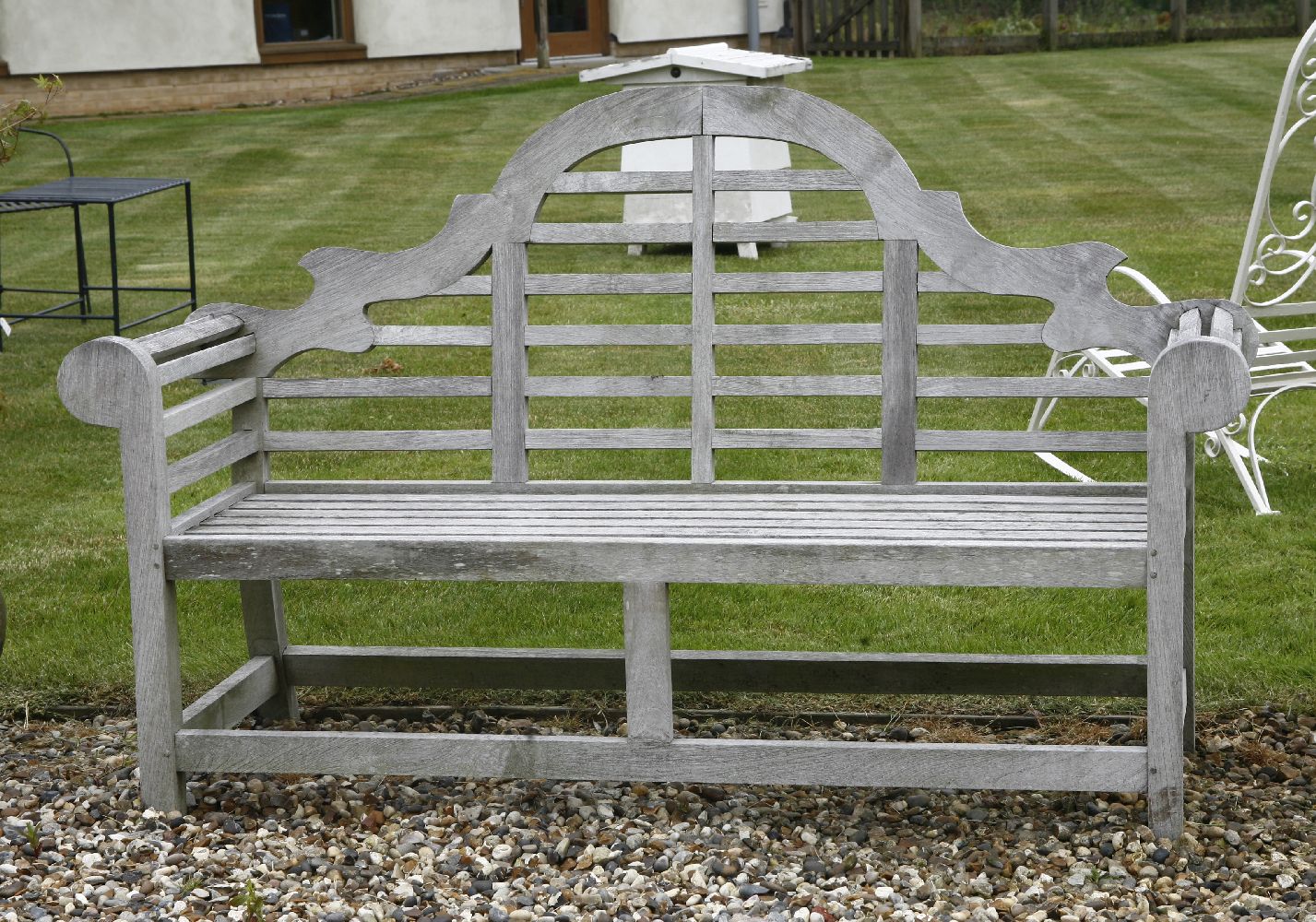 A teak Lutyens style garden seat, with shaped back and slatted seat, 166cm wide