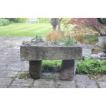 A small carved stone trough, planted with alpines, on two granite supports, 70cm wide, 42cm deep