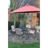 A metal garden dining suite, comprising a table, four open armchairs, and an umbrella