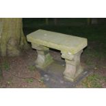 A small stone garden seat, with shaped supports to either end, 90cm wide