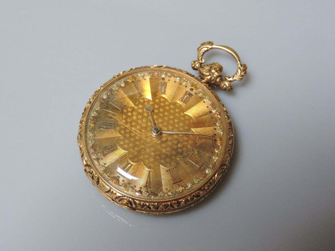 An 18ct gold key wound open faced pocket watch, with gold engine turned dial with three colour