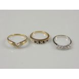 A 9ct gold diamond set wishbone ring, size P½, a 9ct white gold five stone cubic zirconia ring, size