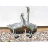 A pair of cast metal garden ornaments, in the form of geese