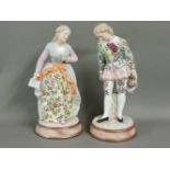 A pair of Sitzendorf porcelain figures of a gentleman and a lady, circa 1890, each upon a faux
