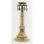 A brass candlestand,19th century, probably Indian, with seven leaf-shaped drops, three missing,