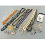 A collection of costume jewellery, including a graduated ivory bead necklace, an amber bead