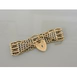 A 9ct gold seven row gate link bracelet, with 9ct gold heart shaped padlock