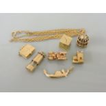 Seven assorted gold charms, including five 9ct gold charms, a charm in the form of a boat stamped