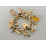 A 9ct gold charm bracelet, with a collection of 9ct gold charms, including a car, champagne