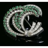 A white gold, emerald and diamond spray brooch, circa 1950, with rows of graduated claw set