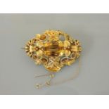 An early Victorian oval cut citrine and filigree mounted brooch, tested as approximately 18ct