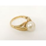 A gold single cultured pearl ring, with textured leaf three prong shoulders, marked 18, 5.42g