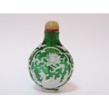 A Chinese green glass scent bottle and stopper, overlaid in white with mythical birds and