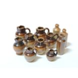 Eight miniature brown stoneware jugs, and three ink bottles, tallest 3cm high