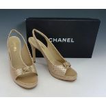 A pair of Chanel gold metallic leather peep-toe slingback high-heeled shoes, with gilt metal bow