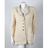 A Chanel Boutique cream wool tweed jacket, four pockets to front, brass shield emblem to buttons, '