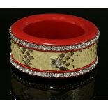 A Dolce and Gabbana red slave bangle,with a central snakeskin band, with applied 'DG' paste set