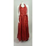 A 1950s red satin evening dress, halter-neck and full skirt in a woven floral pattern