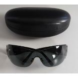 A pair of Prada sunglasses, black tinted lenses, stamped 'Prada' to side bar, in hard case