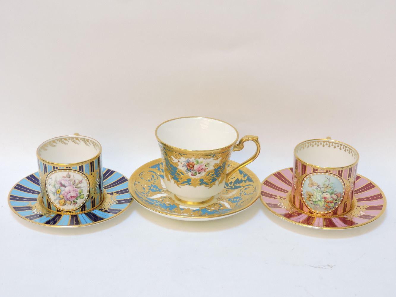Three Lynton porcelain cups and saucers, each decorated in coloured enamels, with hand painted