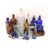 A collection of glass poison and chemist's medicine bottles, including blue, green, brown and clear,