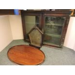 A Victorian glazed mahogany hanging cabinet, 88cm wide, an Edwardian oval mahogany tray, and a