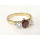 A gold ruby and diamond three stone ring, tested as approximately 18ct gold