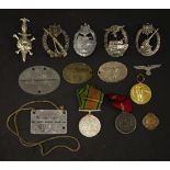 Fourteen items of militaria, to include German badges, two British WWll service medals, Stalag lVB