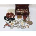 A leather clad jewellery box, containing various brooches and beads