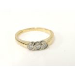 An 18ct gold diamond three stone ring, size L